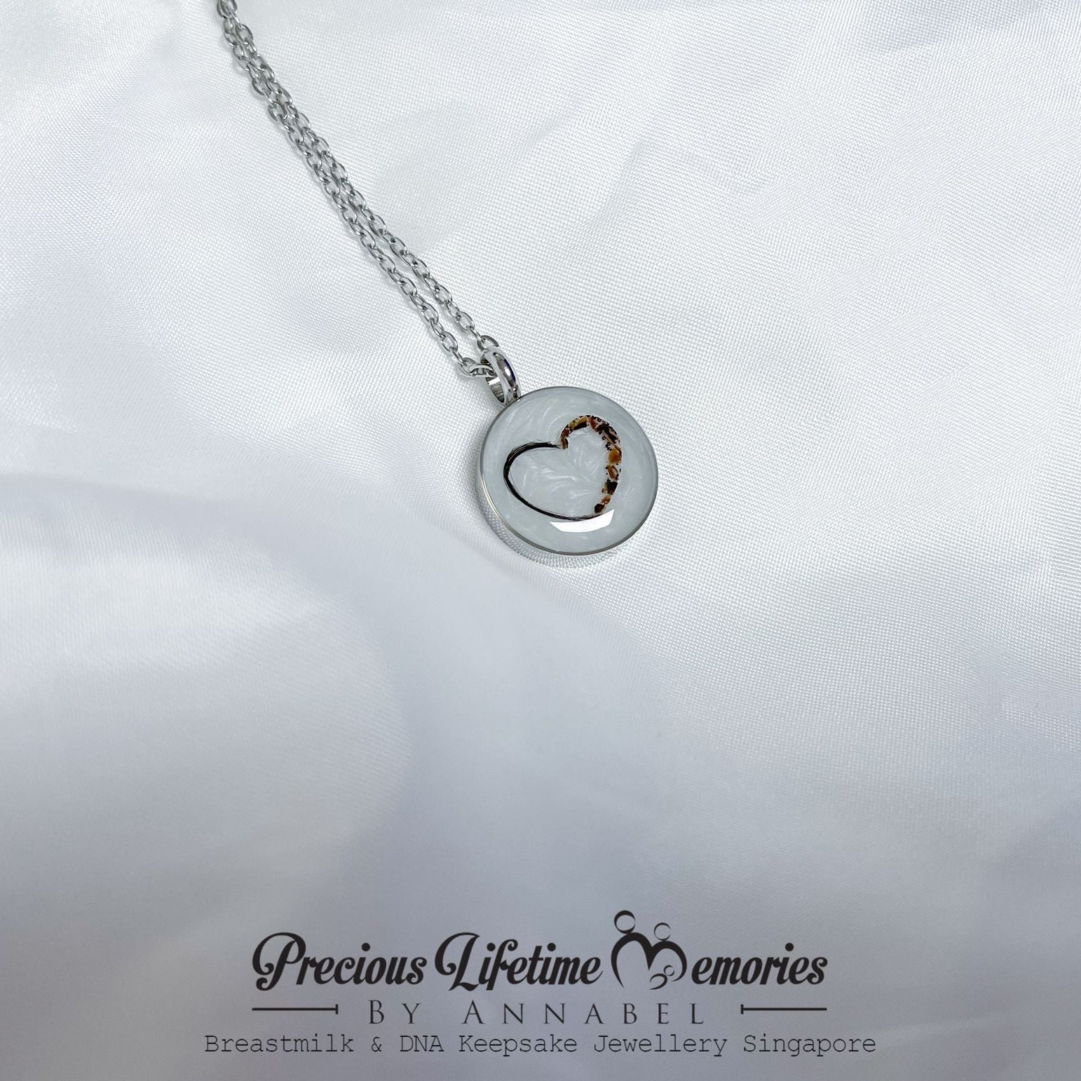 Silver necklace with a heart-shaped pendant on a white background, featuring 'Precious Lifetime Memories by Annabel'.