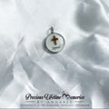Pendant with cross design on a white fabric background, featuring 'Precious Lifetime Memories by Annabel'.