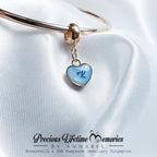 Jewelry with a blue heart charm on a white satin background, featuring 'Precious Lifetime Memories by Annabel'.