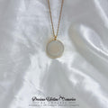 Necklace with a round pendant on a white fabric background, featuring the brand 'Precious Lifetime Memories by Annabel'.