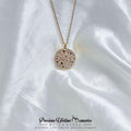 Necklace with a round, speckled pendant on a white satin background
