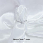 Silver ring with a white stone on a white satin fabric, branded 'Precious Lifetime Memories by Annabel'.
